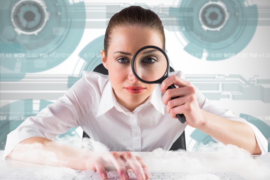 Analyst looking through magnifying glass